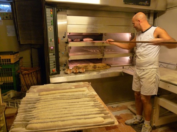 Les baguettes cuites sont récupérées avec une grande pelle en bois.